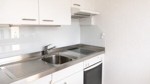 A kitchen with stainless steel appliances, a double sink, and white cabinetry.
