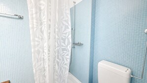 A bathroom with a shower, toilet, and a towel rack. - Cozy studio in the city centre (Art 13) (Zürich)