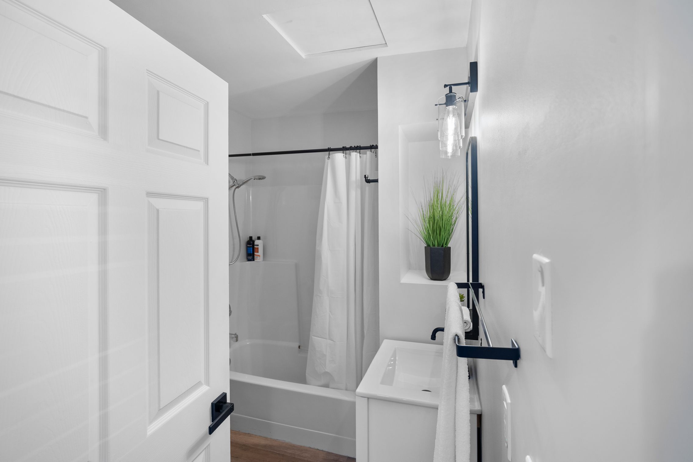 A modern bathroom with a bathtub, shower, and a sink.