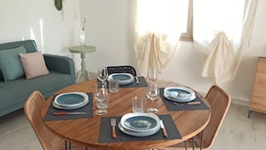 A dining table set with blue plates, glasses, and cutlery, surrounded by wicker chairs. - Villa 21 - A - Two Bedroom Villa, Sleeps 4 (Budoni)
