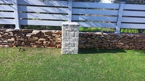 A stone wall with a white fence in the background. - Villa 21 - B - Two Bedroom Villa, Sleeps 4 (Budoni)