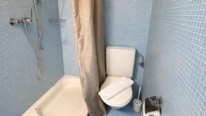 A bathroom with a bathtub, toilet, shower, and a toilet paper holder. - Practical studio in the city center (Art 7) (Zürich)