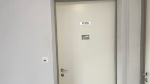 A white door with a number plate, a small window, and a door handle. - Practical Studio nearby Lake (Cross 6) (Zürich)