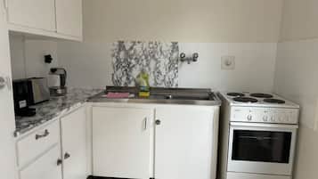 Horno, parrilla de estufa, cafetera y tetera y utensilios de cocina