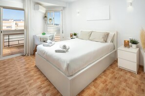 A modern bedroom with a large bed, a desk, and a balcony. - Apartment 'Plazamar 039' with Sea View, Wi-Fi and Air Conditioning (Torre del Mar)