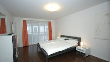 Une chambre à coucher avec un lit, une table de chevet et une fenêtre avec des rideaux.