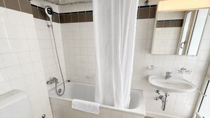 Une salle de bain avec une baignoire, des toilettes et un lavabo.