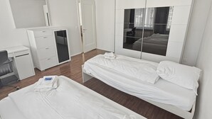 Habitación de hotel con cama, escritorio, armario y un espejo grande.