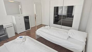 2 habitaciones, escritorio y tabla de planchar con plancha
