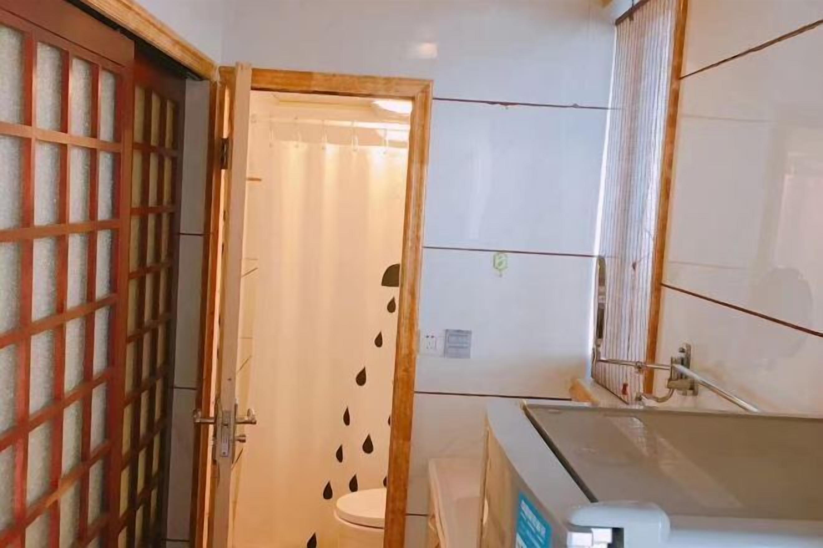 A bathroom with a toilet, a sink, and a mirror.