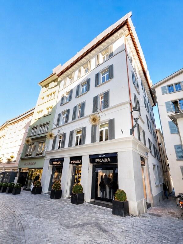 A multi-story building with storefronts including Prada and a frozen shop.