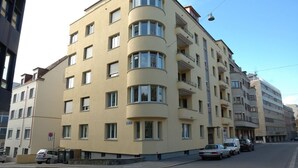 A multi-story building with a curved facade, multiple balconies, and a street view. - Spacious 1BDR near Lake and Opera - Mill 3.11 (Zürich)