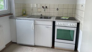 Uma cozinha compacta com lava-louças embutida, pia e forno duplo.