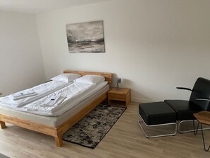 Relax in a serene bedroom with a comfortable bed, a bedside table, and a cozy reading nook.