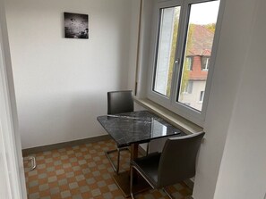 Simple, functional room with a checkered floor and a table for four.