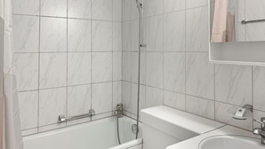 A bathroom with a bathtub, a shower, and a sink. - Lovely studio near center - Crown 1 (Zürich)