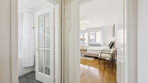 A modern bedroom with a bed, bedside table, and a view of the outside. - City-studio on top floor - Crown 48 (Zürich)