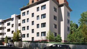 A modern multi-story residential building with a flat roof, multiple windows, and a parking area in front. - Amazing big studio city center (Sun 7) (Zürich)