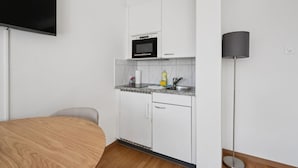 Eine kleine Küchenzeile mit Mikrowelle, Spüle und Arbeitsfläche.