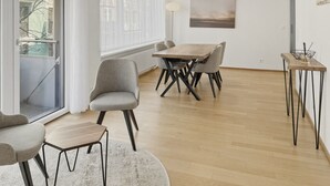 Un soggiorno moderno con zona pranzo, ampie finestre e vista esterna.
