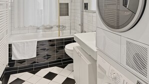 A modern bathroom with a black and white checkered floor, a white toilet, a sink, and a large mirror. - 2BR near lake (Flower 23) (Zürich)