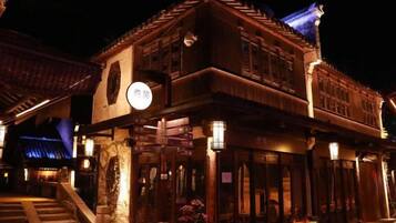A traditional building with a staircase leading to the entrance, a signboard, and a lantern.