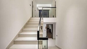 A modern staircase with a glass railing leading to an upper floor. - Your City Pinghua Impression Inn (Kunshan)