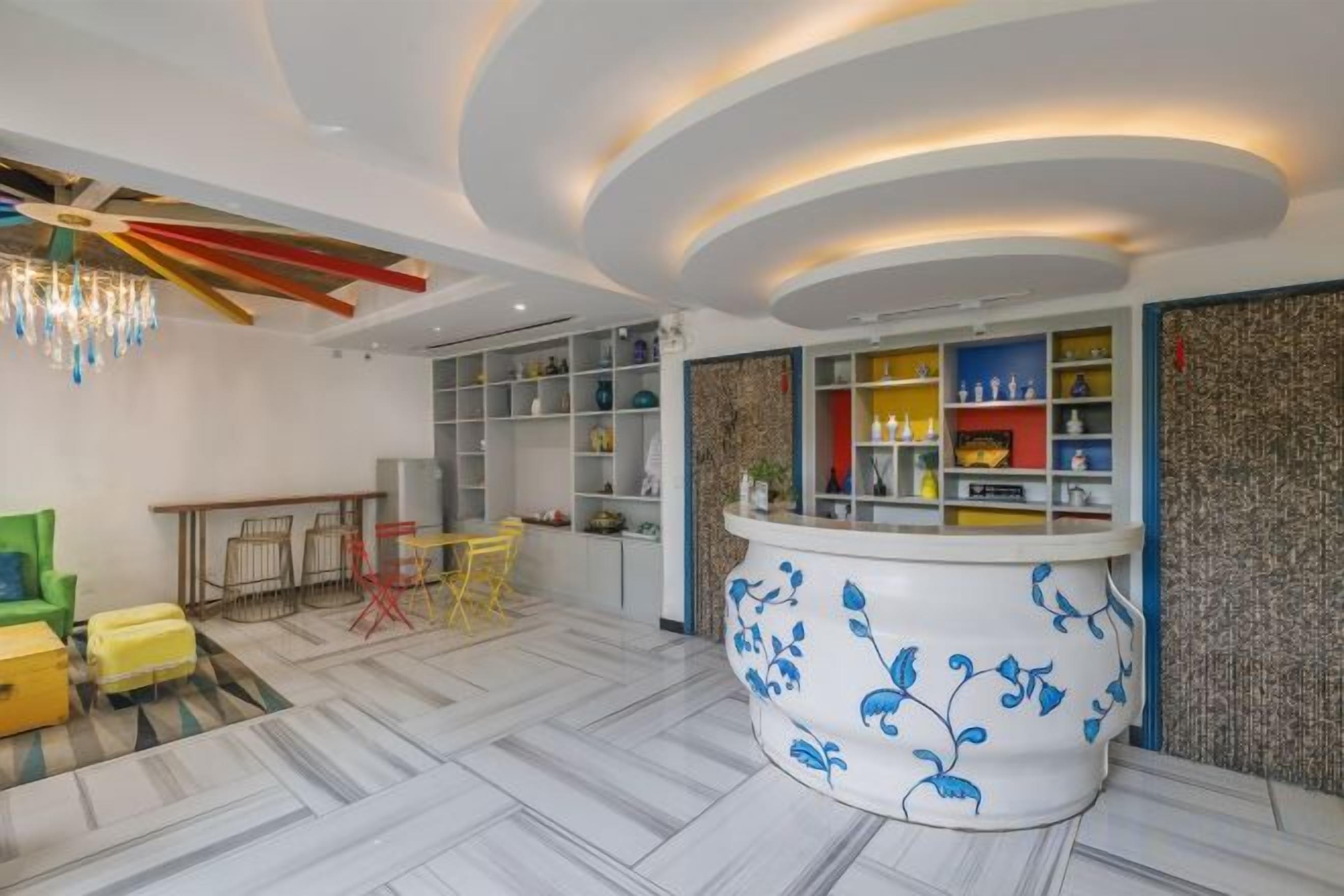 Un hall d’hôtel moderne comprenant un comptoir d’accueil, un espace salon et un plafond décoratif.