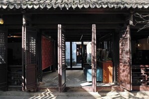 A traditional Japanese entrance with a tiled roof, wooden pillars, and sliding doors. - Your City Pinghua Impression Inn (Kunshan)
