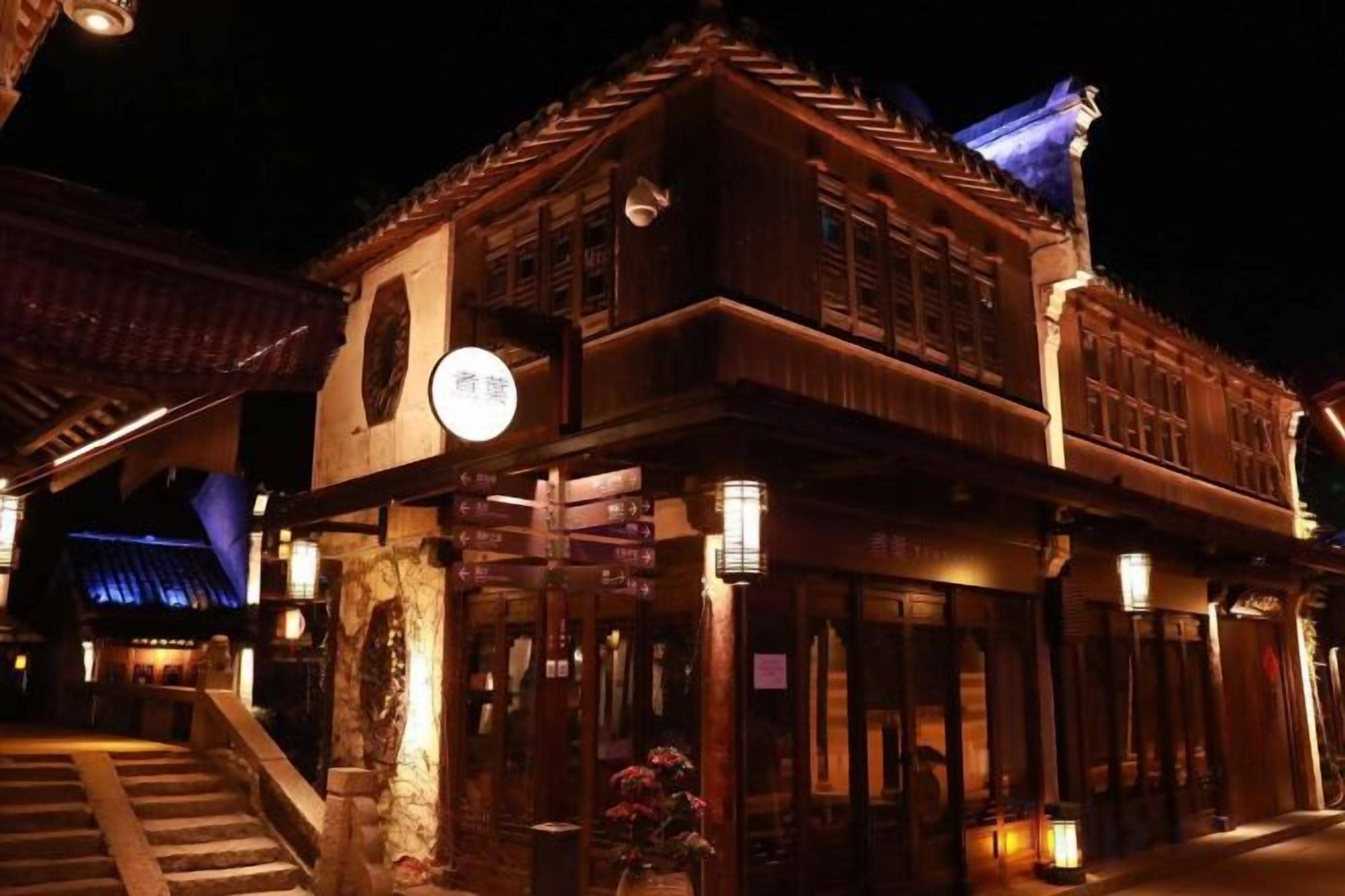 Un edificio tradicional con un letrero, una escalera y un farol.