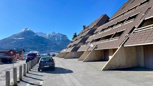 A row of modern, multi-story buildings with a mountain backdrop. - Beautiful studio with magnificent view (Briançon)