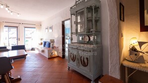 Un vaste espace de vie comprenant une table à manger, des chaises, un canapé et un meuble décoratif.