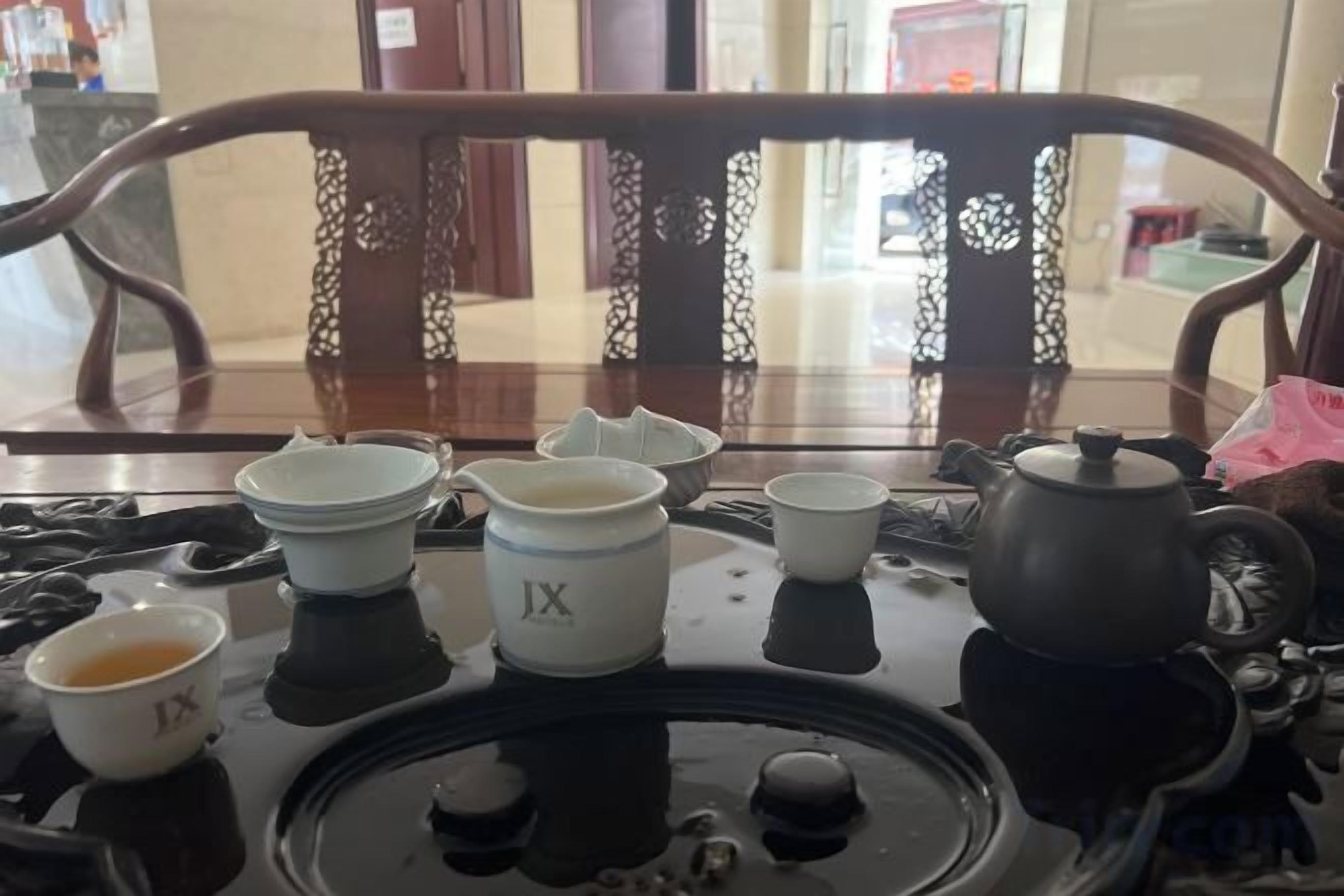 A table with a teapot, several cups, and a small bowl.