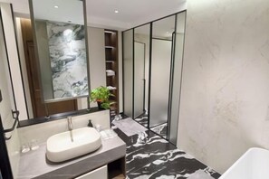 A modern bathroom with a marble sink, a large mirror, and a black and white patterned floor.