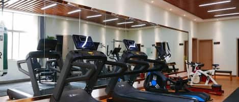 A gym with treadmills, stationary bikes, and exercise equipment.