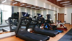 A gym with treadmills, stationary bikes, and weight machines.