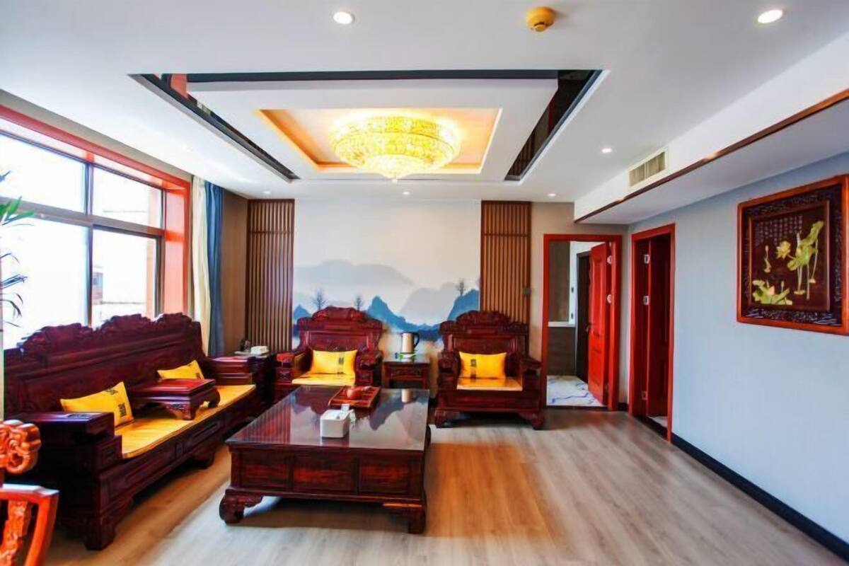 A traditional-style room with a sofa set, a coffee table, and a wall with a mountain painting.
