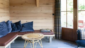 A wooden interior with a bench, cushions, and a woven table. - Holiday Home in Name - Namur (Gedinne)