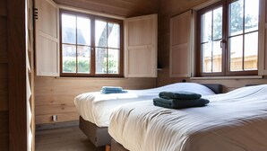 A bedroom with two beds, wooden walls, and large windows. - Holiday Home in Name - Namur (Gedinne)