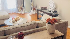 Una sala de estar moderna con un sofá, una mesa de centro y un televisor montado en la pared.