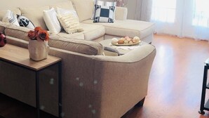 Una sala de estar moderna con un sofá modular, una mesa de centro y una lámpara de techo contemporánea.