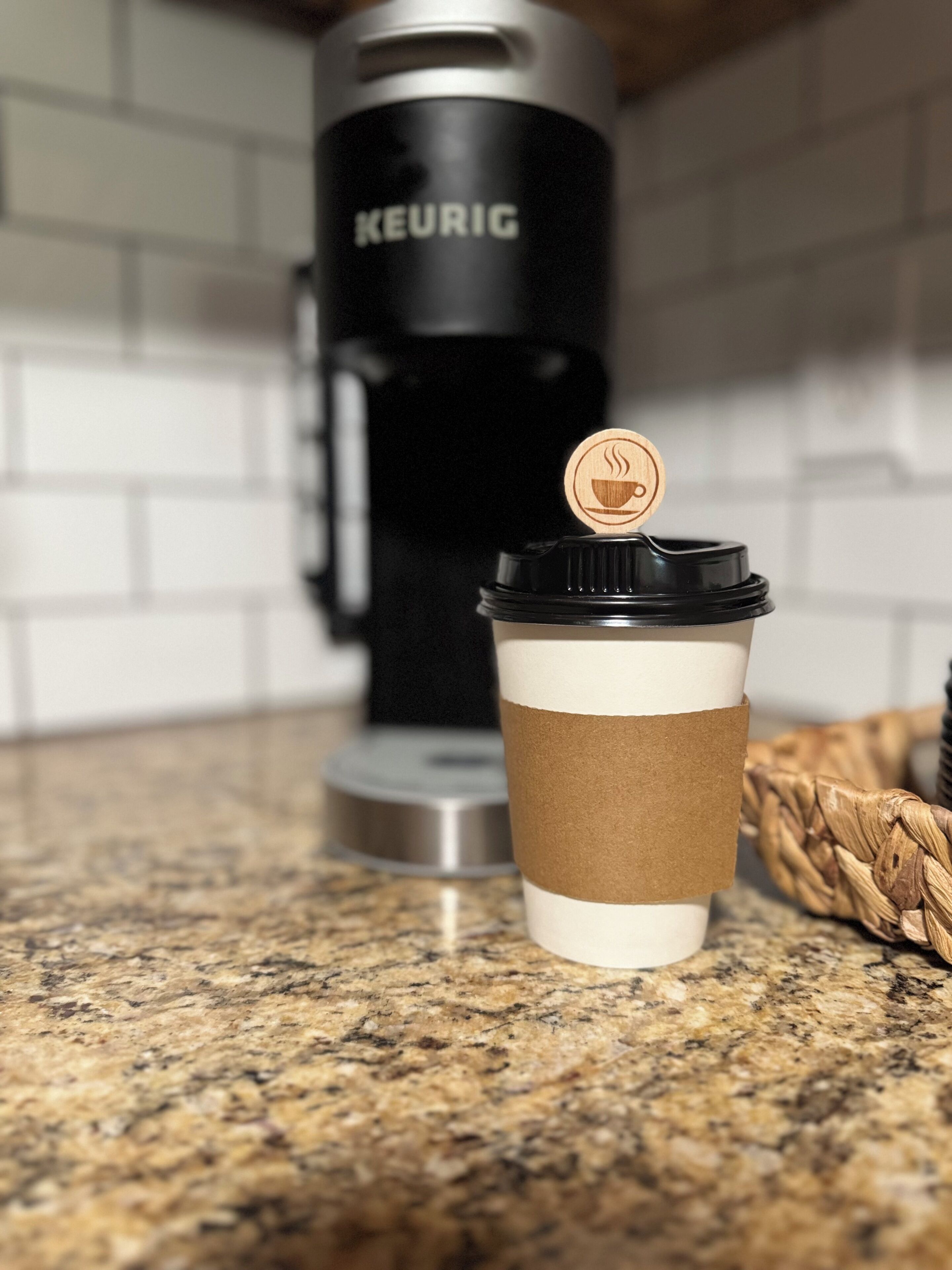 Una taza de café con tapa de madera sobre una encimera de cocina.
