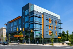 A modern building with large windows, a glass facade, and a street-level entrance. - Modern Luxury | DC | Free Parking (Arlington)