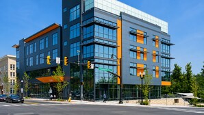 A modern building with multiple floors, large windows, and a prominent orange accent wall. - Modern Luxury | DC | Free Parking (Arlington)