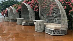 A modern high-rise building with multiple balconies and a wet ground, suggesting recent rain. - Cozy Clean Nice Puri Mansion Apartment (Jakarta)