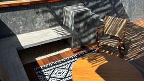 A rooftop pool area with a wooden deck, a seating area with a chair, and a pergola with string lights. - #NEW*Down Town Loft pool in the heart of Cancun (Cancún)