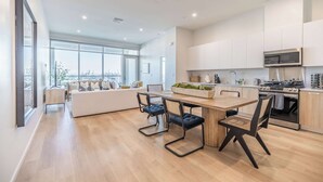 A modern kitchen with a dining area, large windows, and a city view. - @ Marbella Lane - Panoramic Delight Dream Escape! (Long Beach)