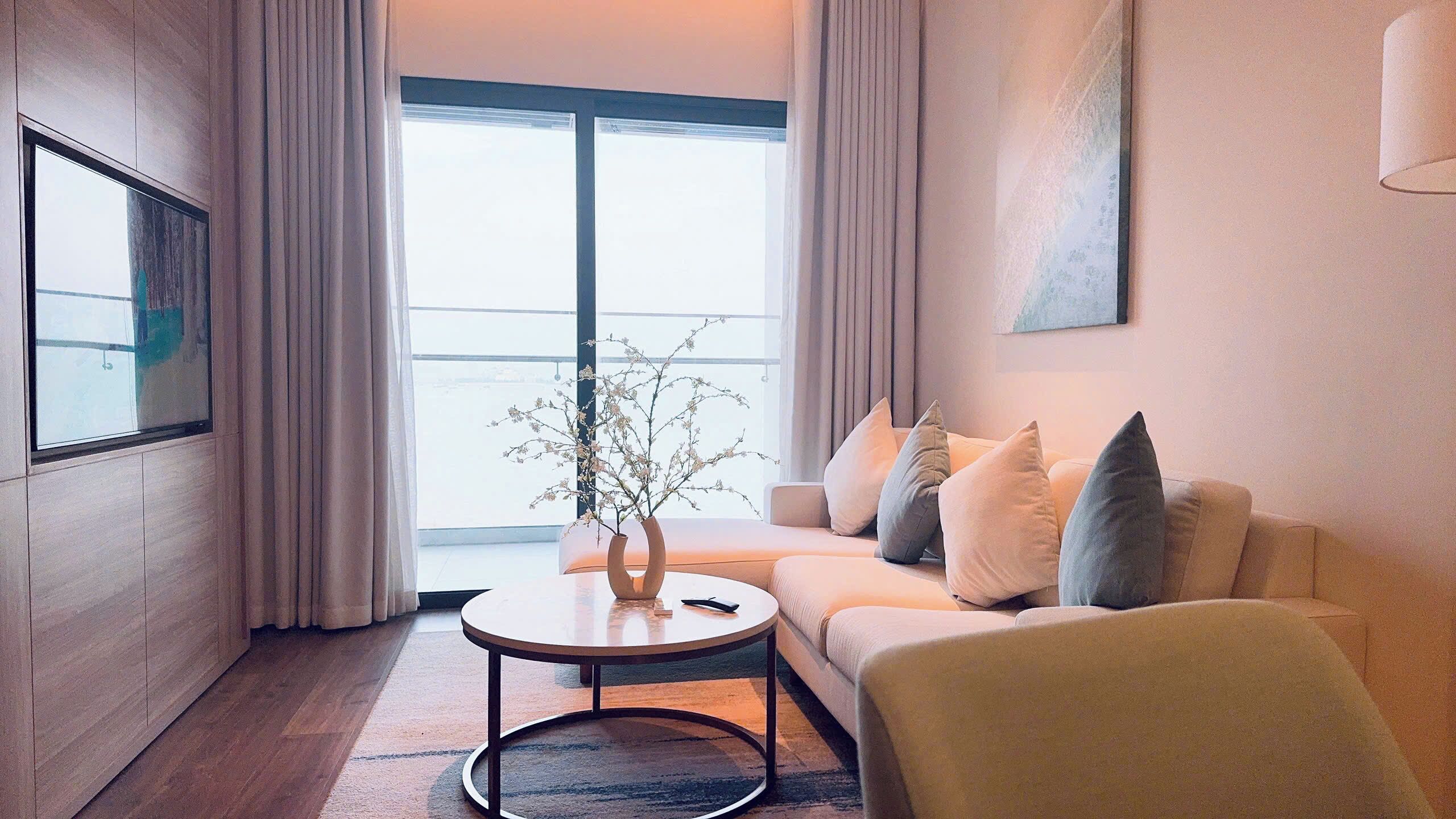 Un salon moderne avec un canapé, une table basse et un vase rempli de fleurs.