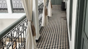 A corridor with a checkered floor, white curtains, and a metal railing. - Charming, recently renovated riad in the medina of Marrakech (Marrakech)