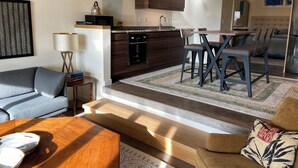 A modern living room with a sofa, coffee table, and a dining area with a table and chairs. - An Apartment with a View: A peaceful getaway in Hudson, NY (Hudson)